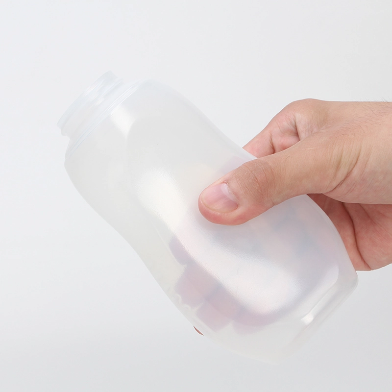 Mano comprimiendo una botella flexible vacía para observar la deformación de la pared